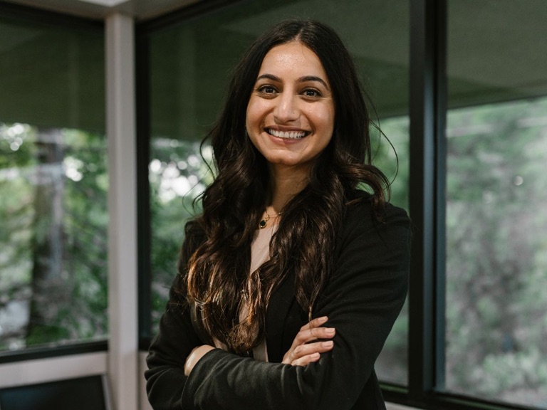 Smiling young recruitment consultant in a black blazer in a modern office